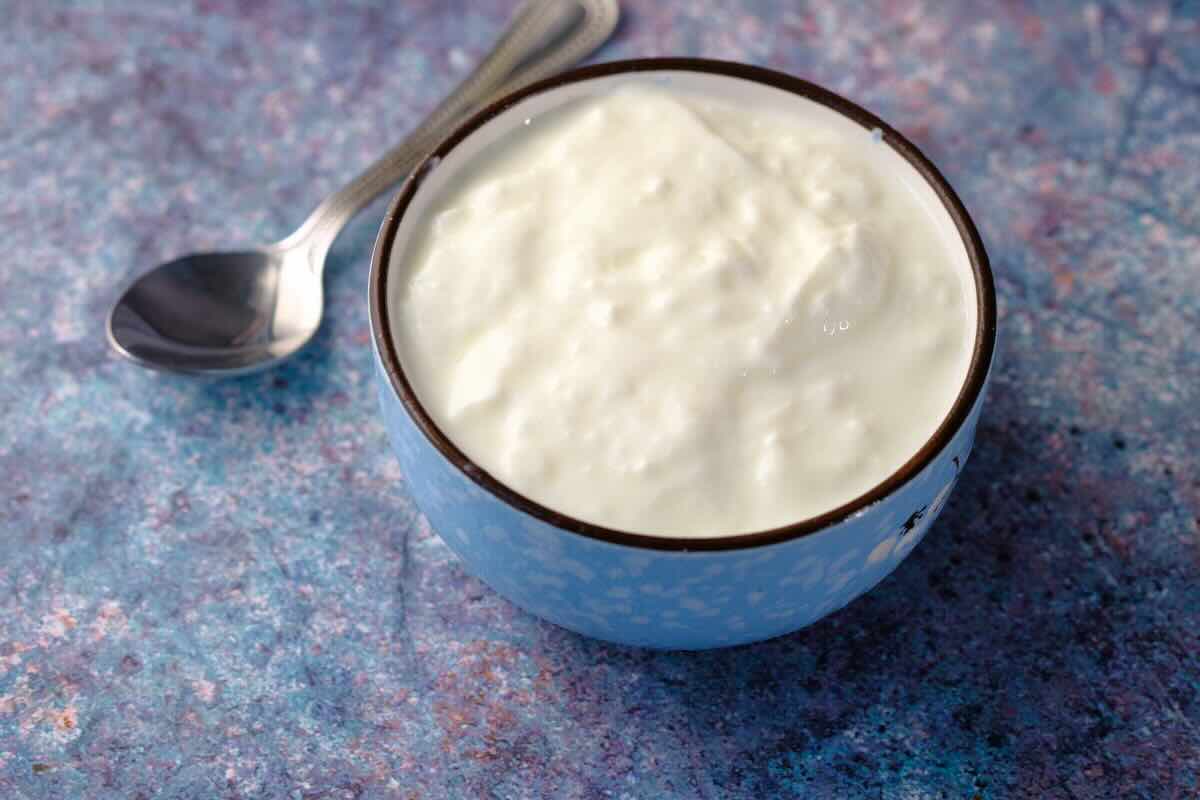 ciotola con yogurt bianco e cucchiaino